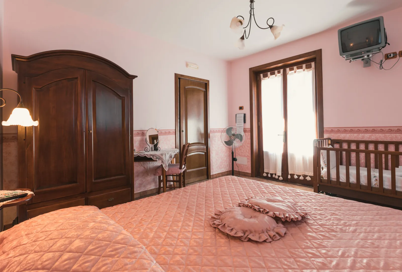 Camera matrimoniale con armadio in legno e culla